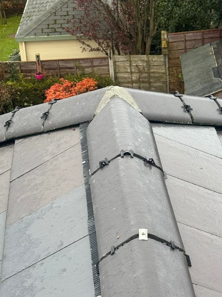Ridge tiles re-bedded along the top of a slate roof